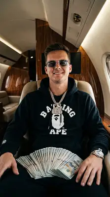 Take the uploaded photo of the person and generate a photorealistic 9х16 image of this person (please make sure to keep facial similarity) in one of the following randomly selected settings:   Leaning against a bright Lamborghini or Rolls-Royce, wearing a tactical vest or puffer jacket, showing off a luxury watch or chain.  Inside a private jet with stacks of cash on their lap, dressed in designer streetwear (like BAPE, Louis Vuitton, or Nike Tech).   Posing in front of a private jet at night, holding fanned-out stacks of hundred-dollar bills, with a confident or nonchalant expression.   Sitting in a luxury car with a starlight ceiling, wearing iced-out chains and sunglasses, mid-conversation or staring coolly ahead.   Standing against an urban graffiti backdrop, throwing up hand gestures while wearing a designer scarf or hoodie, heavy jewelry, and rings.   The final image should have a high-contrast, bold, Instagram-worthy aesthetic. Use realistic lighting and textures. Make sure the background, outfit, and pose reflect confidence, wealth, and a street-smart vibe. Rotate between settings randomly each time this is run.